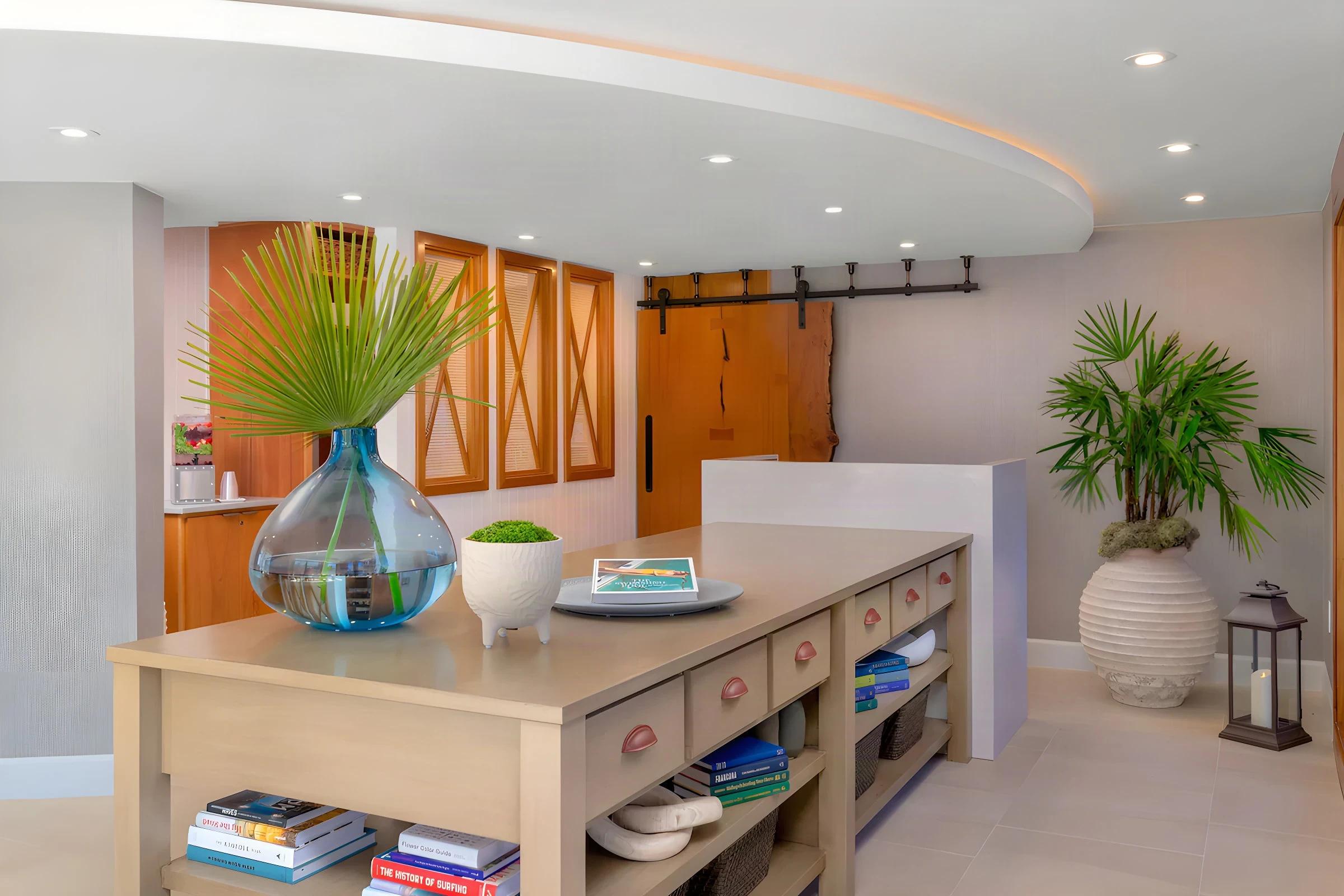 Beach Terrace Inn reception with a timber console, palm fronds and a sliding barn door