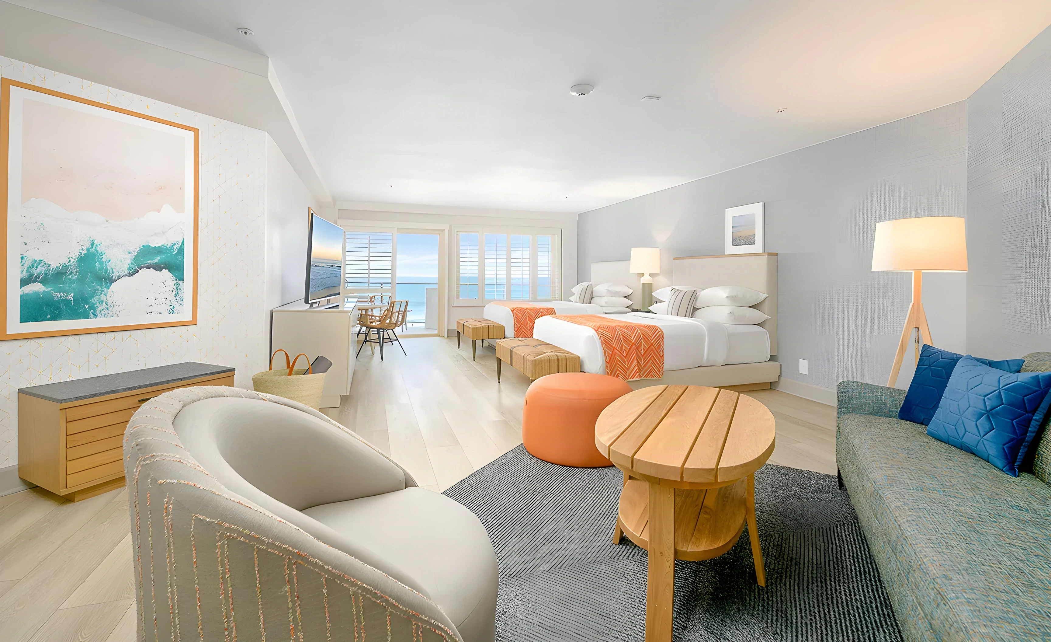 Beach Terrace Inn suite sitting area with a green sofa, round wood table and floor lamp
