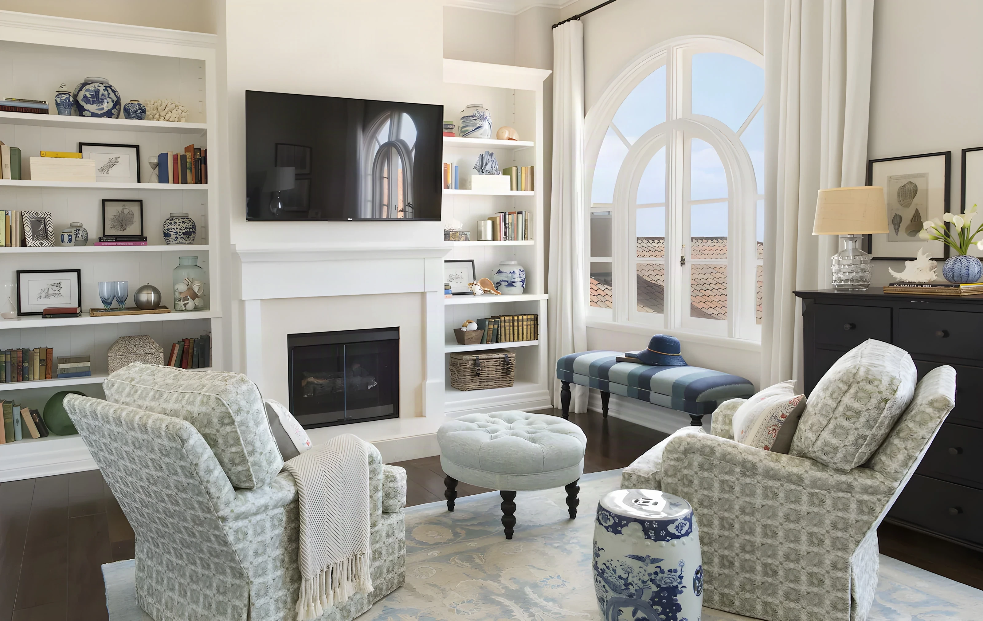Guest room fireplace wall with built-in shelving and patterned armchairs at Casa del Mar