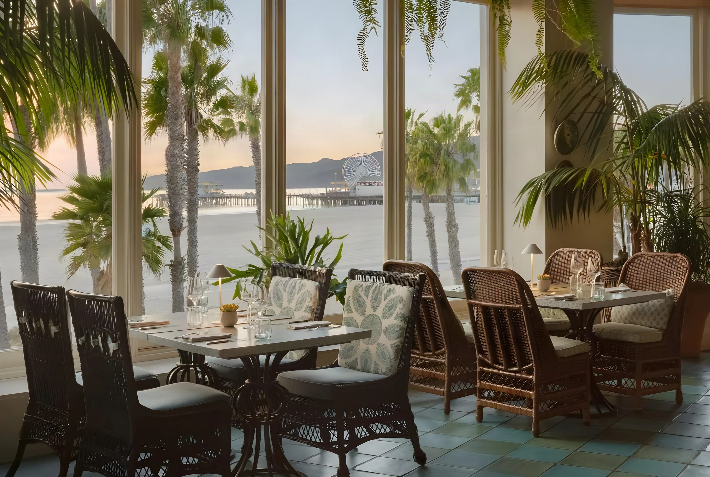 Oceanfront dining room at Casa del Mar with wicker chairs and views of the pier