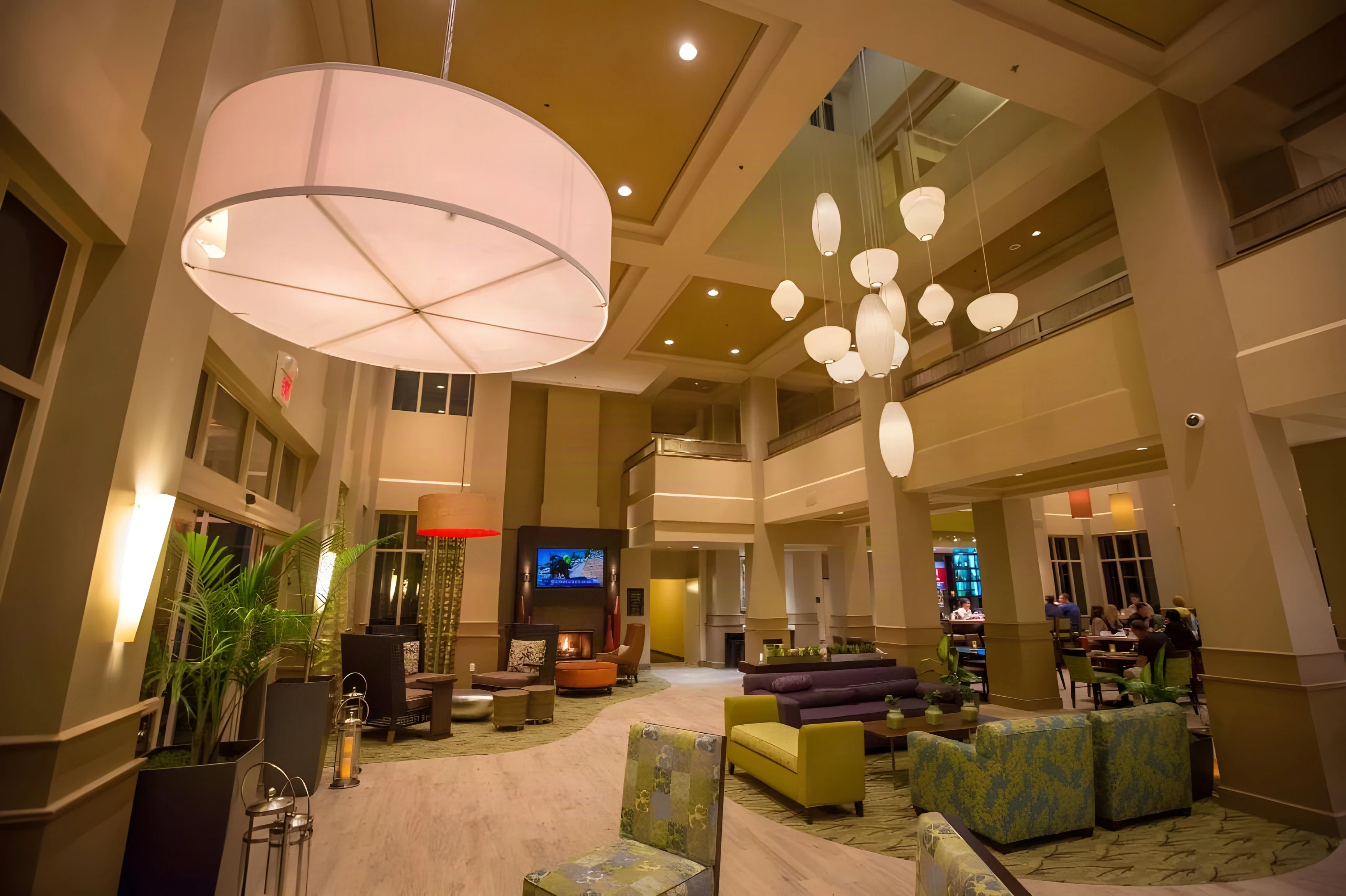 Hilton Garden Inn Montebello lobby lounge with a drum pendant and a cluster of globe lights