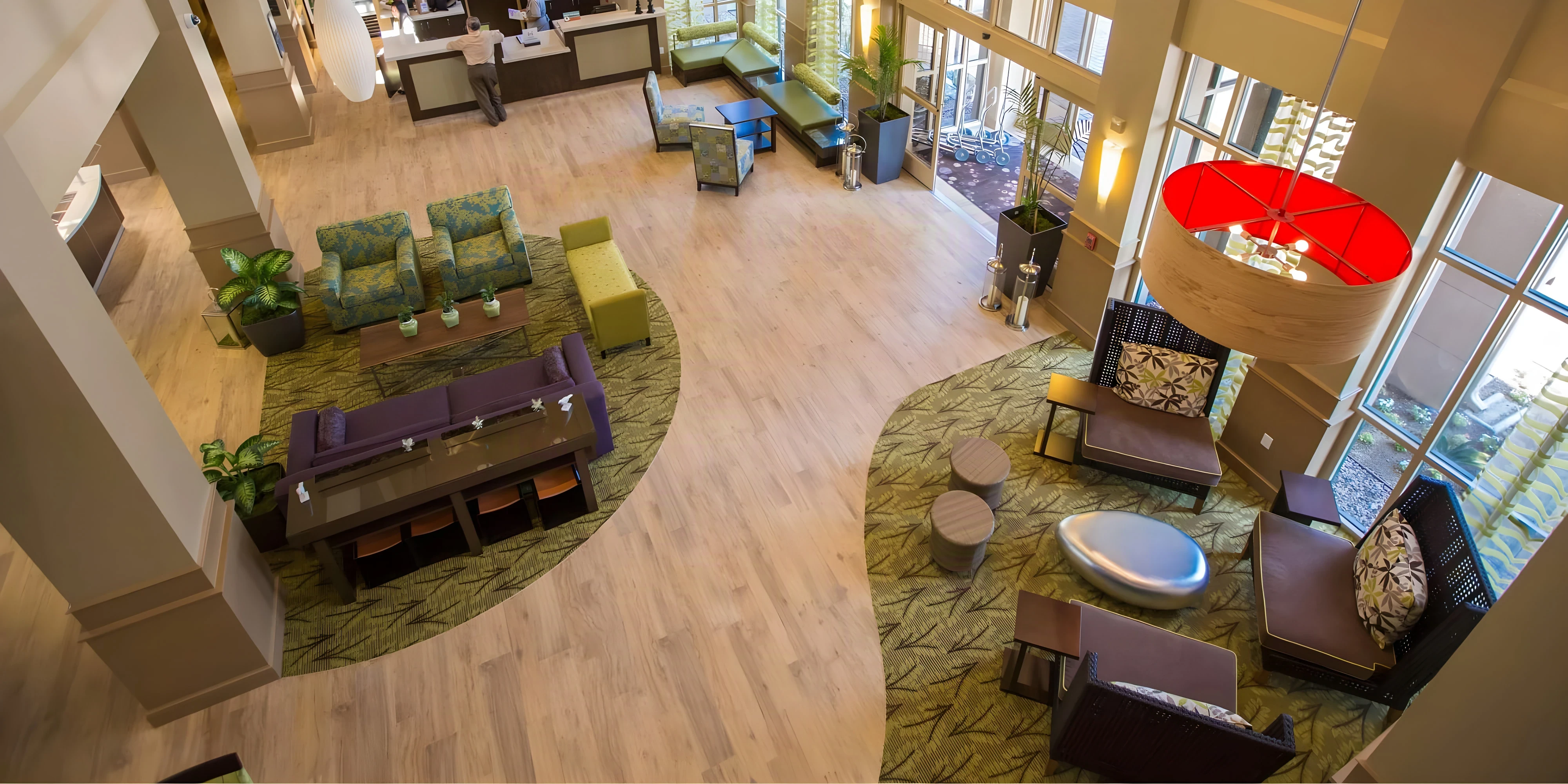 Renovated Hilton Garden Inn Montebello lobby seen from above, with lounge seating and a red pendant light