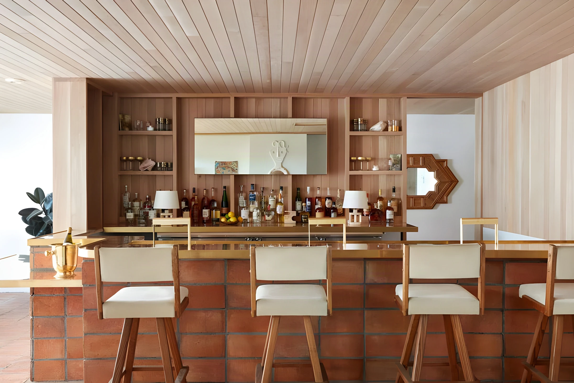 Terracotta tile bar with cream stools and timber shelving in the Laguna Beach hotel