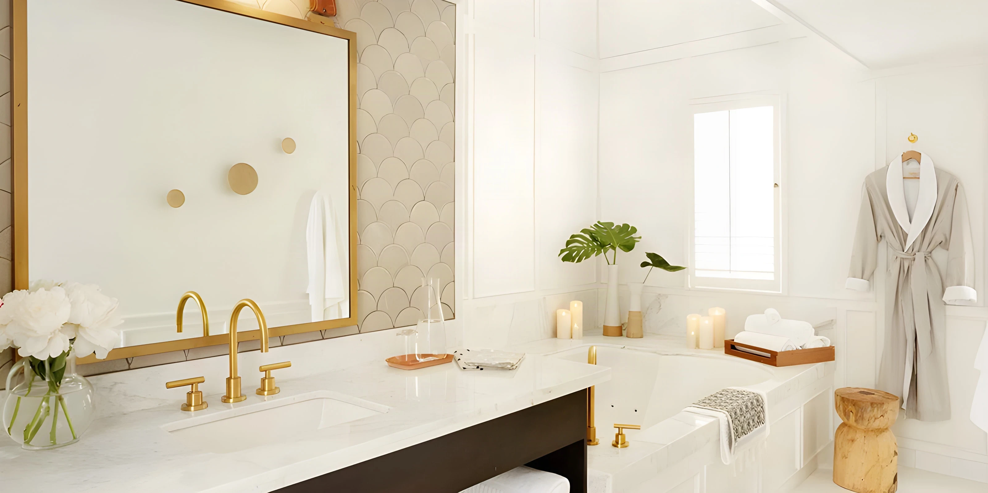 Marble vanity with brass taps, a gold mirror and a robe on a hook at The Landsby