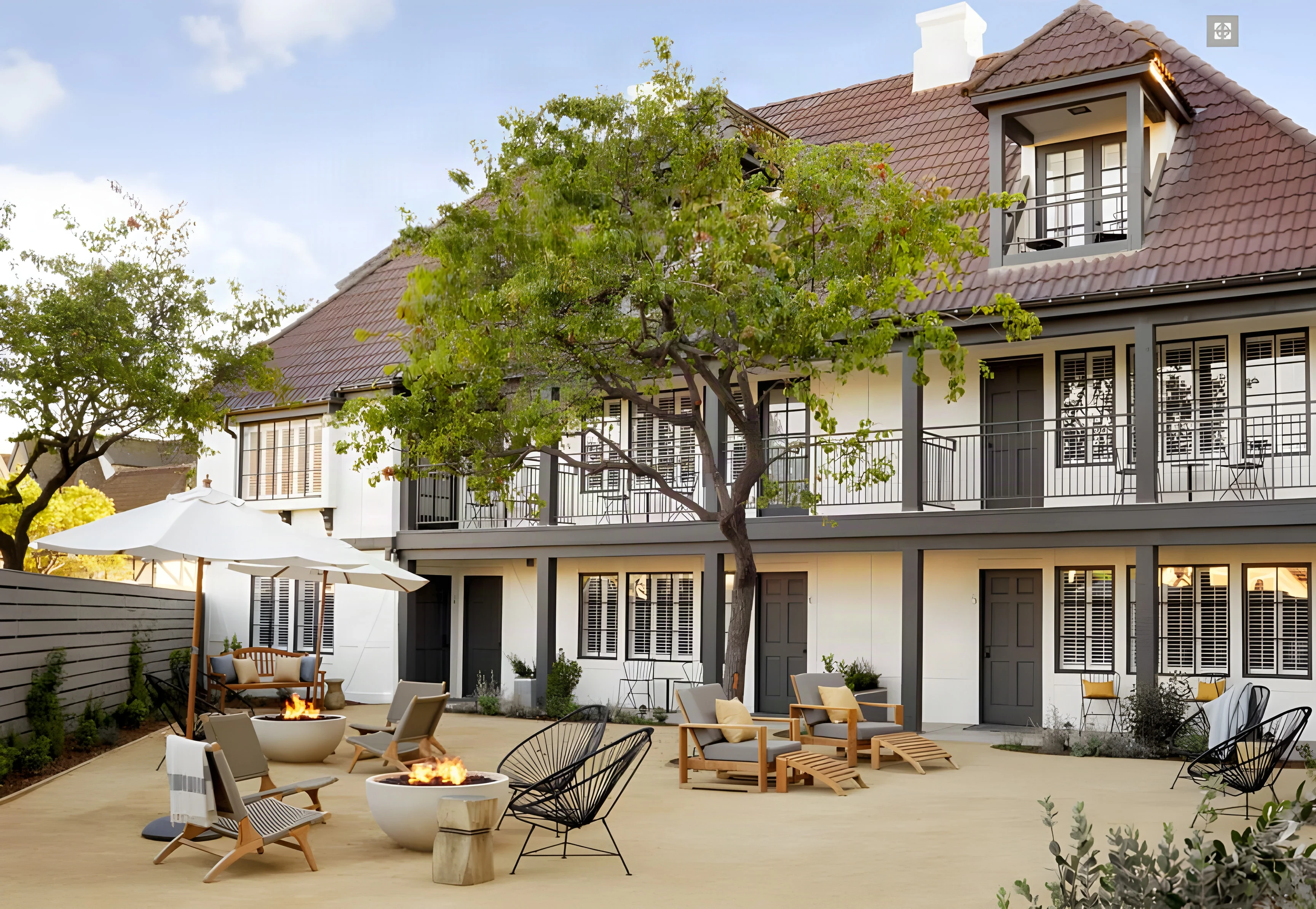 Courtyard at The Landsby with white umbrellas, fire tables and a balconied guest wing