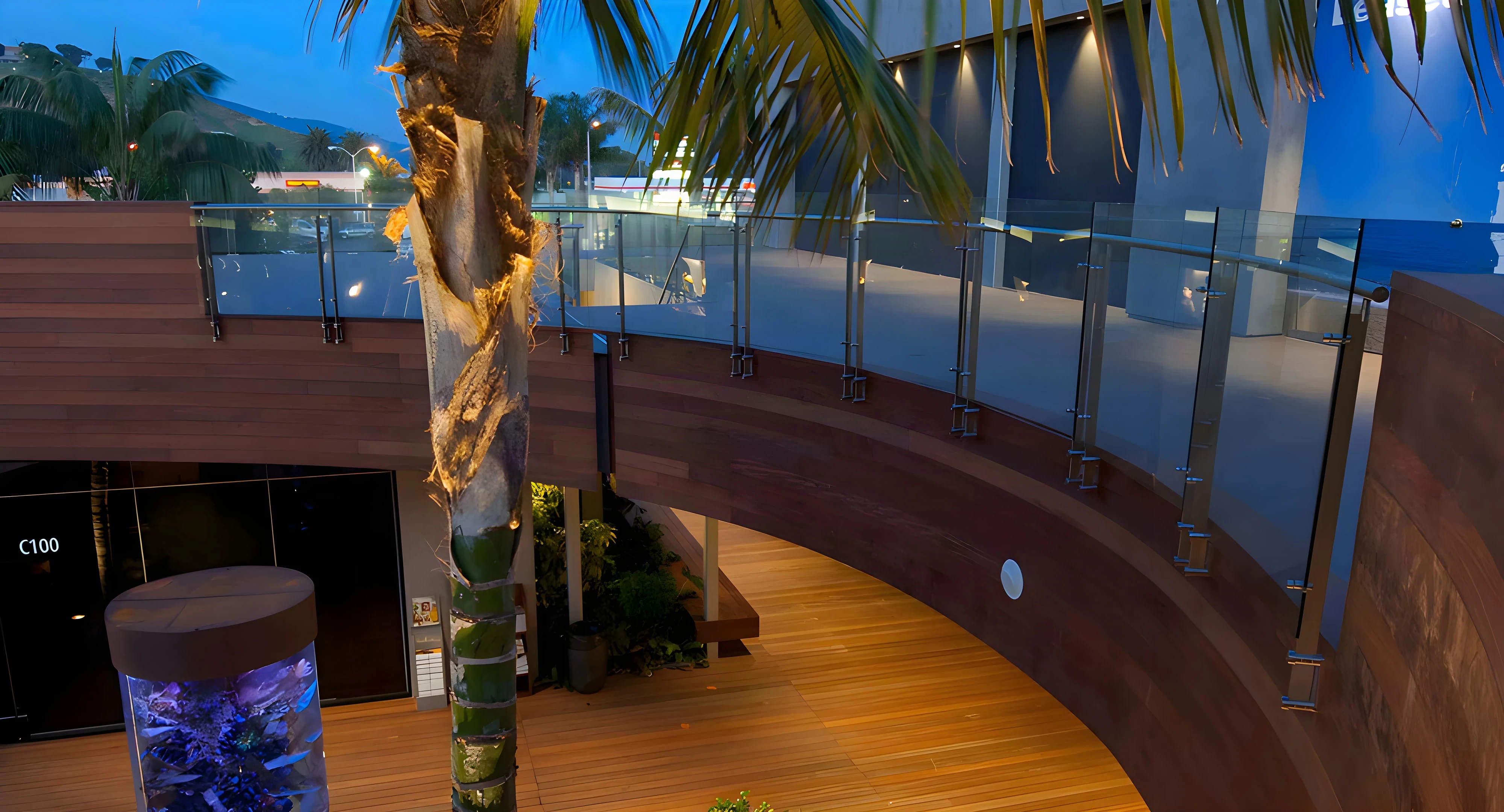 Curved glass railing wrapping the upper level over the Malibu Lumber Yard courtyard
