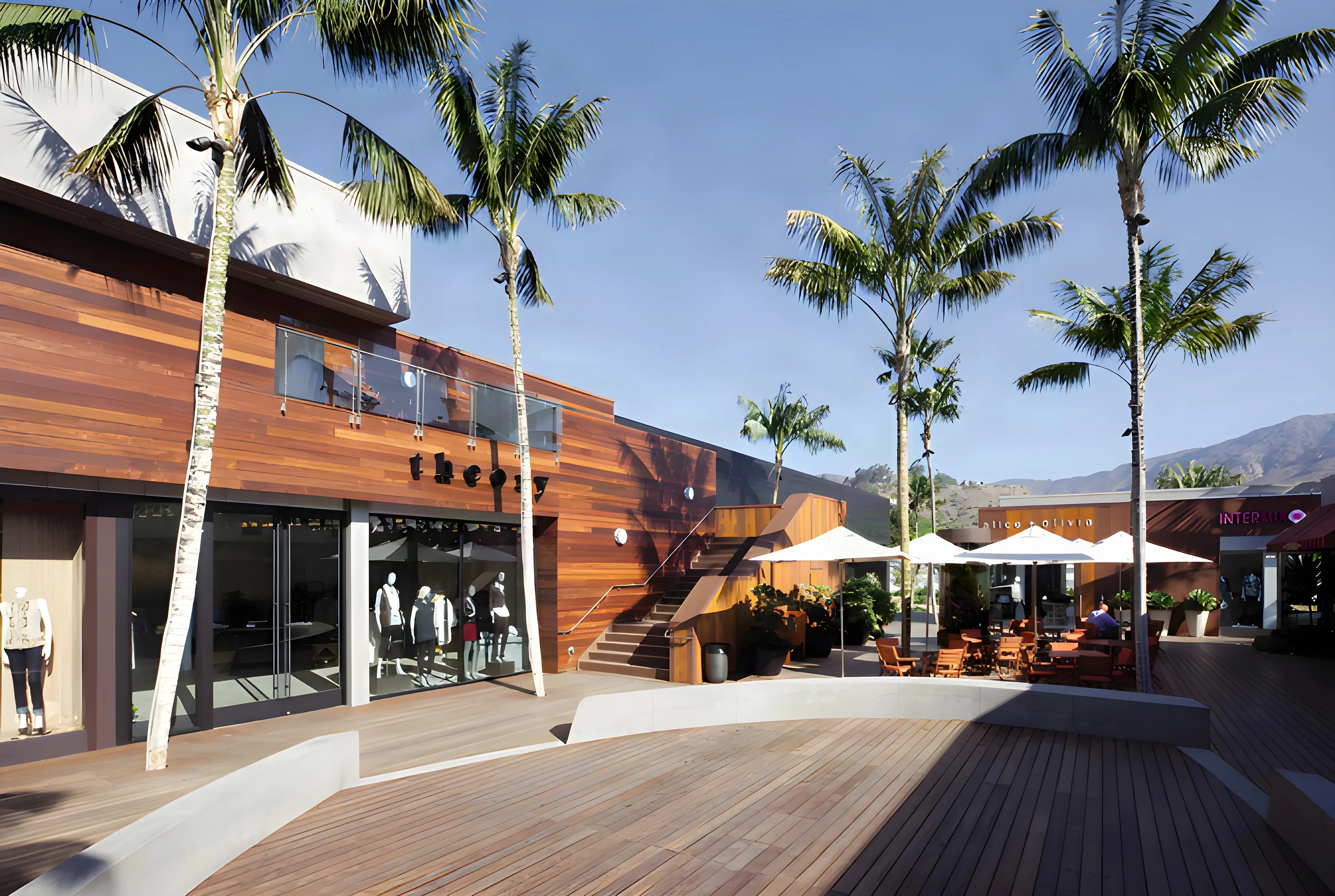 Wood-clad storefronts and a sweeping ipe deck under palms at Malibu Lumber Yard