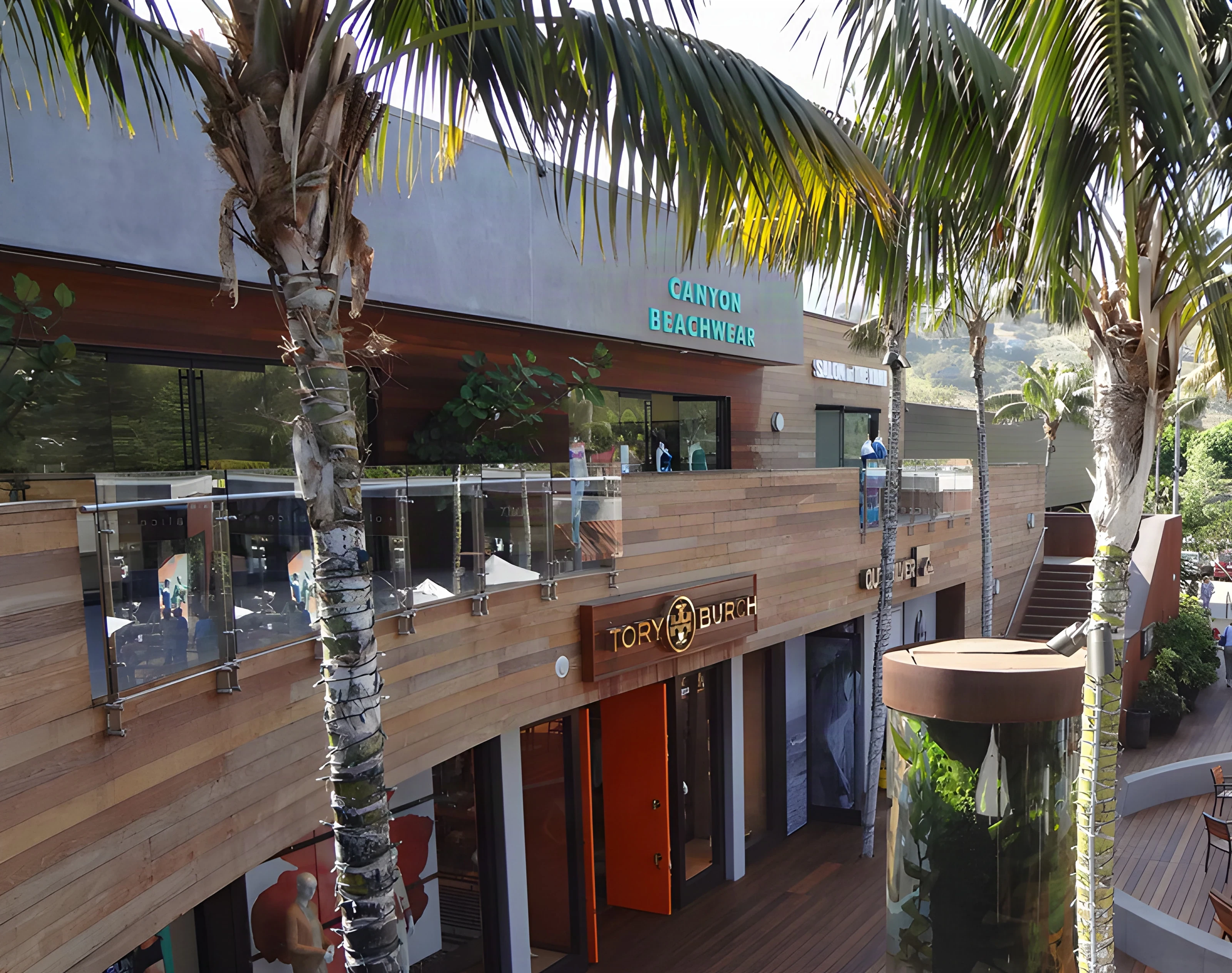 Glass-railed upper walkway above boutique entrances at Malibu Lumber Yard