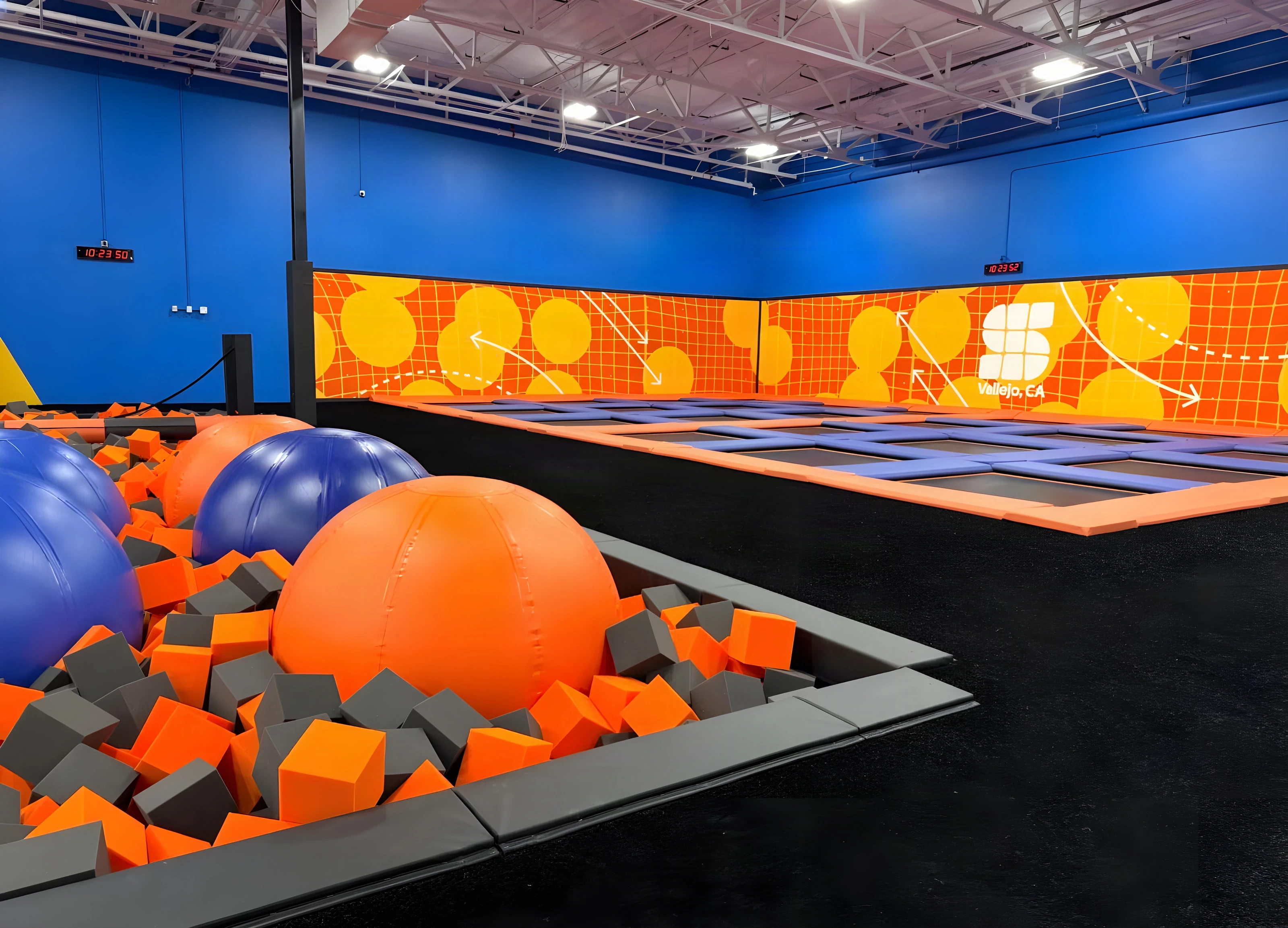 Foam pit with giant orange and blue balls beside the Sky Zone Frisco trampolines