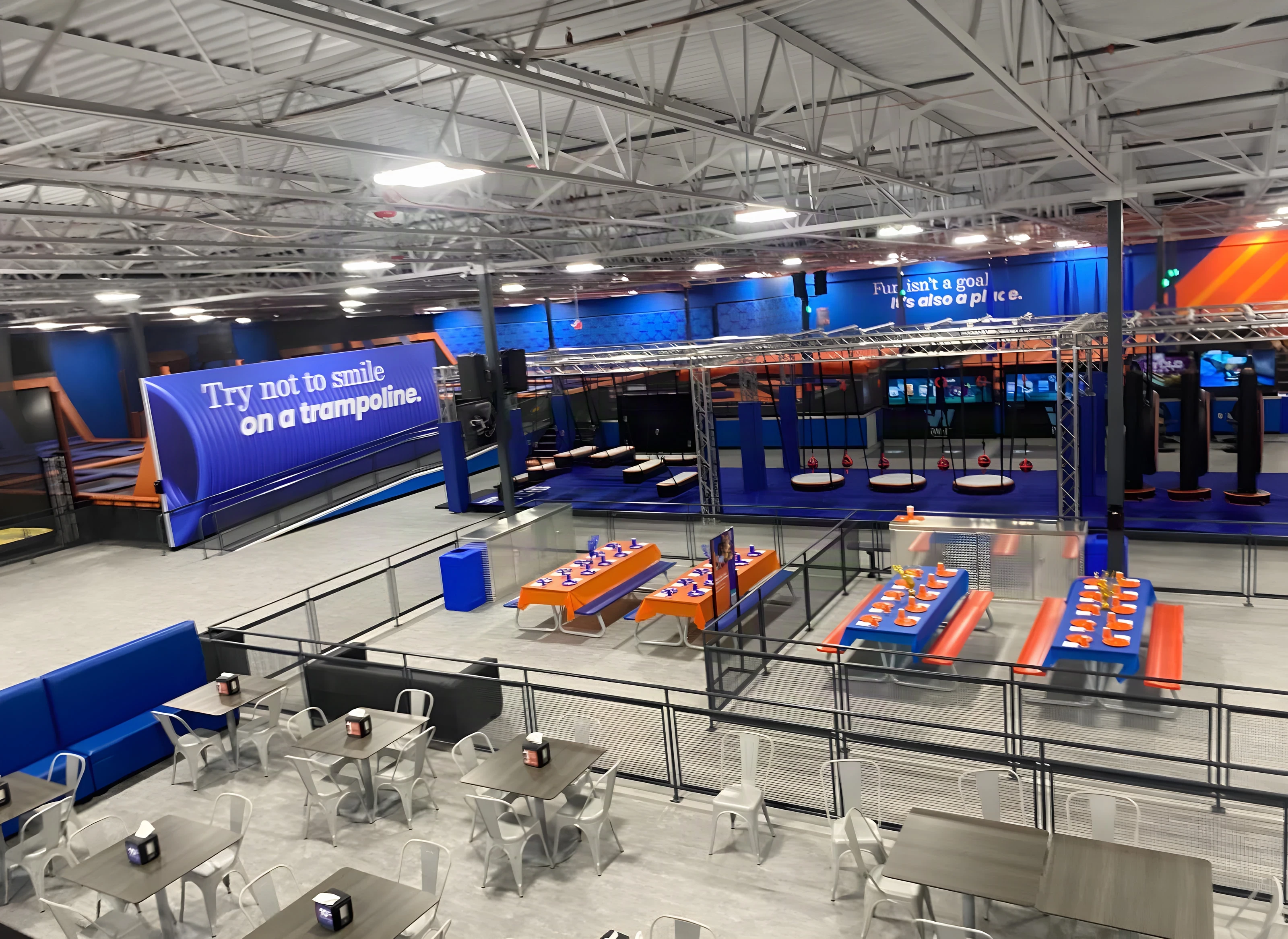 Party tables and seating below the ninja course at Sky Zone Frisco