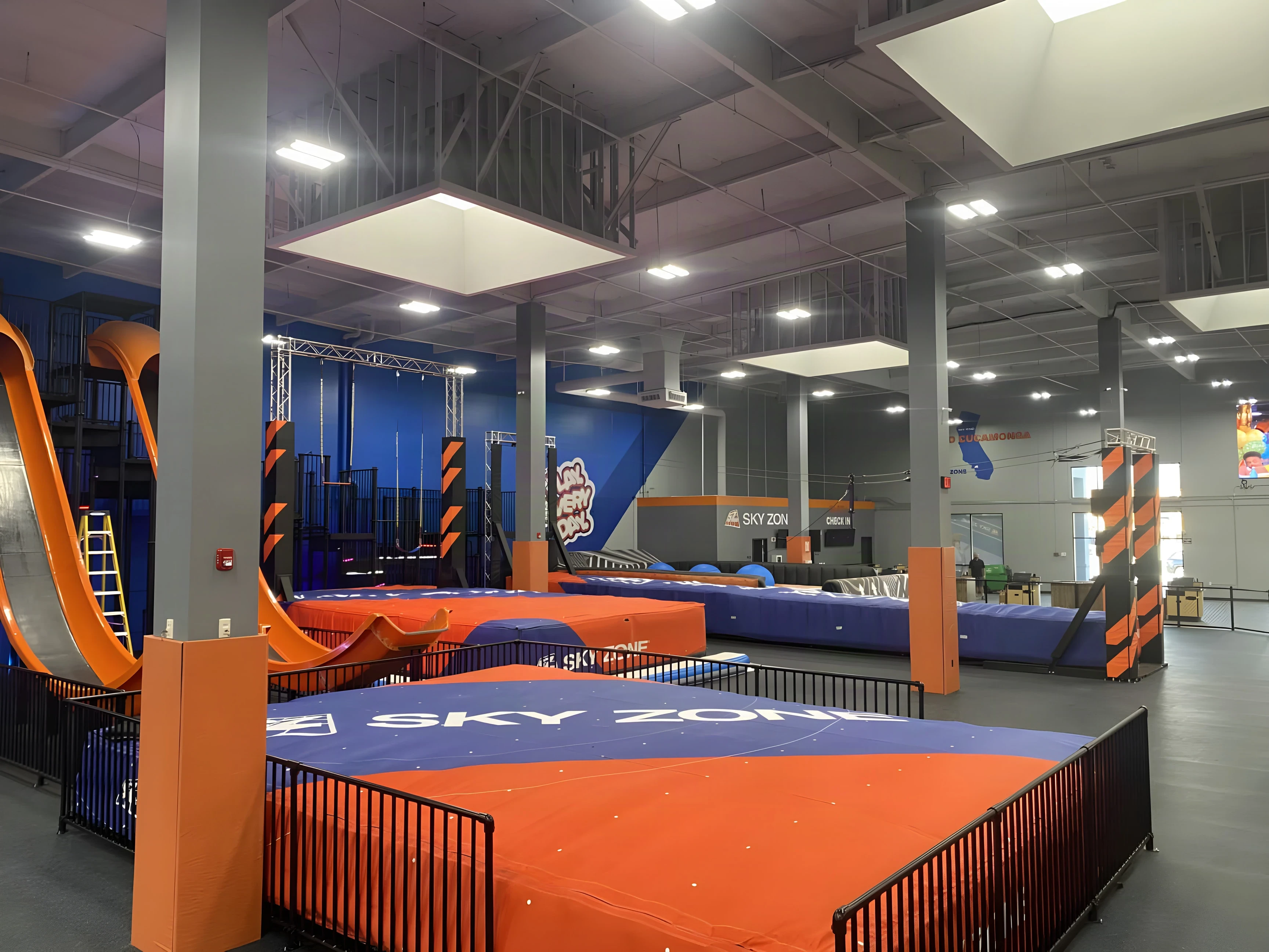 Sky Zone Rancho Cucamonga jump zone with orange slides and a blue and orange air bag