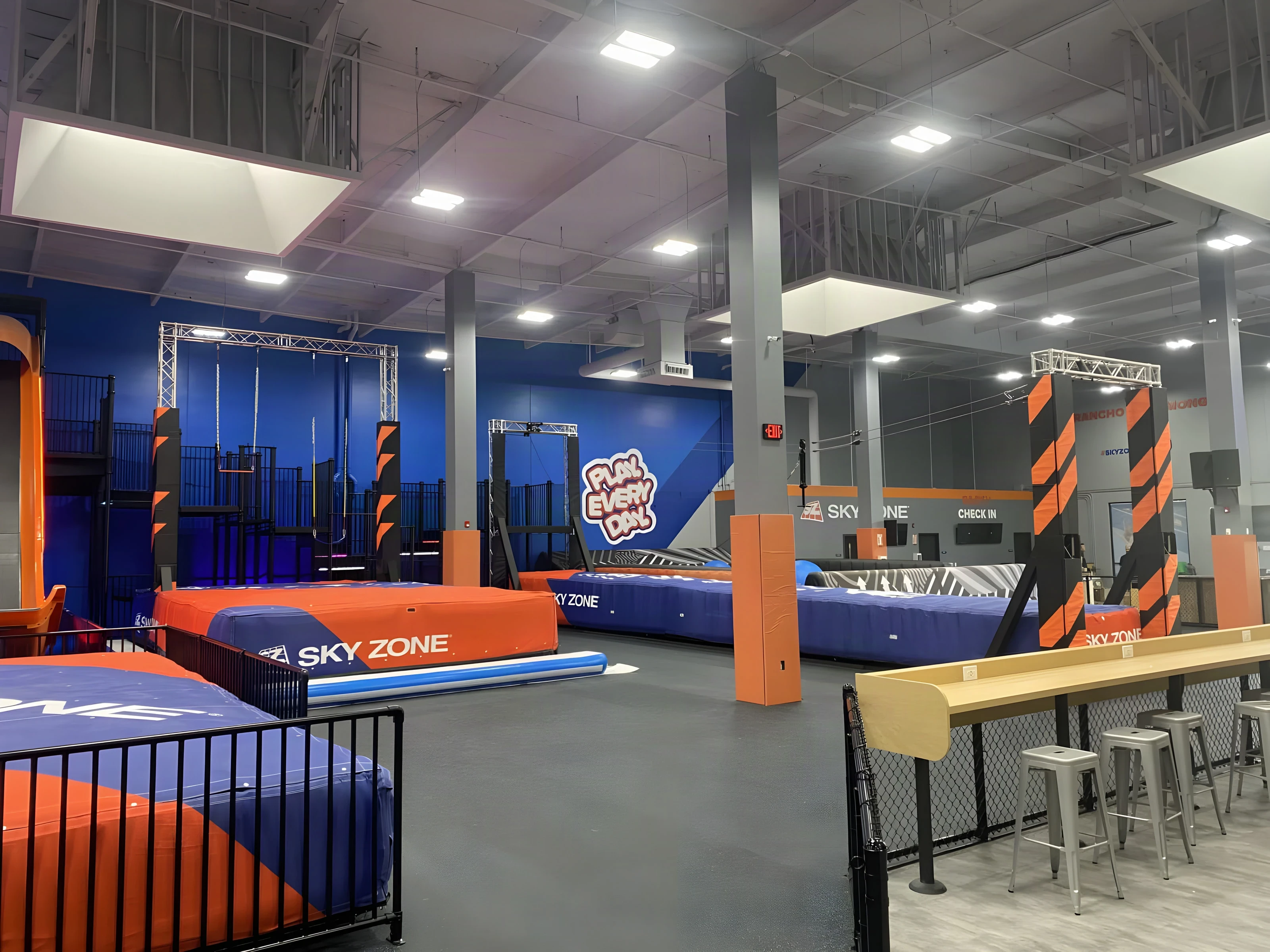 Padded trampoline lanes and café counter seating under skylights at Sky Zone Rancho Cucamonga